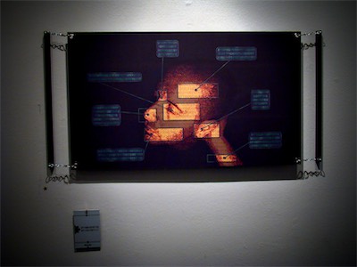 Ego | Gallery Photo — As you can see here, the main ego print that I did, the version of it with just the head in the middle, wasn't actually shown at the show. But I included it in this gallery so you can see a bigger version. Plus, I do use it as an avatar quite often because I like the way it looks. But, here we go with the horizontal chain hang framing with the tag. And the tag doesn't actually say what this is in English. It only says it in binary, like with the rest of them. I thought it was a pretty excellent approach to framing and hanging.