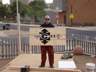 ©haos Gallery Sign — Like a weirdo, I decided I would model my sign and my work while wearing some goggles. Goes nicely with the flame pants, I guess. A mainstay for me at the time. I actually still have a pair of those. A new one. But yeah.