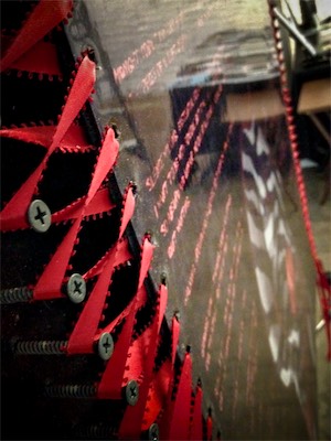 Transparency — There we go... With the ribbon pulled up above the threads on every single screw and tensioned properly and tied at the bottom, we now have a suspended piece of artwork. Something I'd never seen before. I thought it was a bit bizarre. Also took care to make sure that each of the pieces of ribbon were turned in just the right direction.